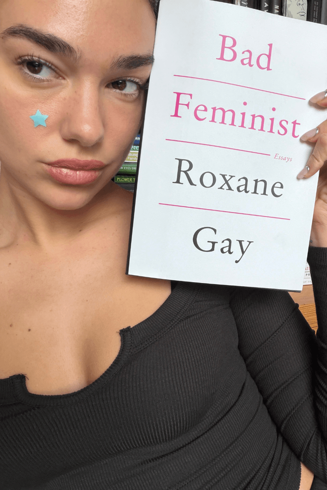 Dua Lipa avec un livre de Roxane Gay